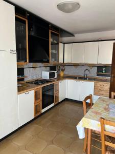 a kitchen with white cabinets and a table in it at Villa Isa in Rio Marina