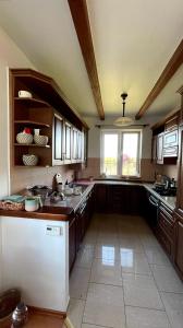a large kitchen with wooden cabinets and a window at Lake View Home in Rajgród