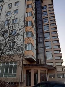 a tall building with a car parked in front of it at Airport apartament in Sîngera