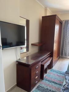 um quarto com uma cómoda e uma televisão de ecrã plano em قريه اكوا فيو الساحل الشمالي em El Alamein