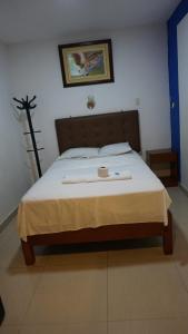 Un dormitorio con una cama con una vela. en Hotel Prados Piura - Oficial, en Piura