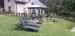 a black bench and an umbrella in a yard at Salamandra in Rajcza