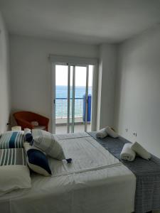 a bedroom with a large bed with a view of the ocean at Bajamar,un lugar mágico in Bajamar