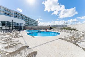 a group of chairs and a swimming pool on a building at Apartament z basenem Polanki Aqua D307 in Kołobrzeg