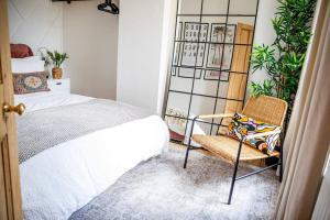 a bedroom with a bed and a chair at Boho Beach House Hot Tub, 3 Bedroom in Cleethorpes