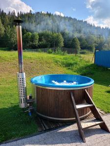 a hot tub sitting in a field next to a heater at Agroturystyka u Chlebków in Ochotnica Górna