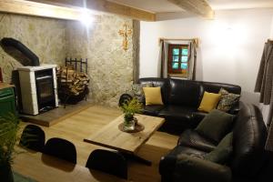 a living room with a leather couch and a table at Rábenka in Janov nad Nisou