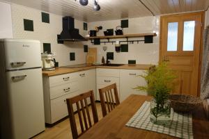a kitchen with a table and a white refrigerator at Rábenka in Janov nad Nisou
