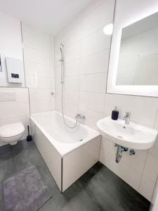 a bathroom with a sink and a tub and a toilet at 3 Zimmer mit 6 Betten, große Küche, neues Bad, 7min zur A1 in Hagen