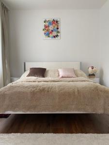 a white bedroom with a large bed with two pillows at Luxury Apart near Lake Bohinj in Bohinj