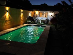 a swimming pool with green water at night at Casa Alquiler Temporario in Tandil