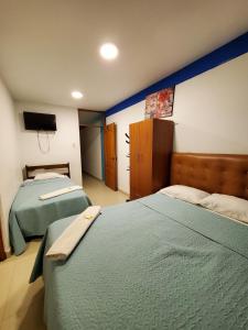 1 dormitorio con 2 camas y TV de pantalla plana en Hotel Prados Piura - Oficial, en Piura