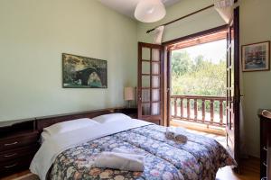 a bedroom with a bed and a large window at Zenios Dionysos - Traditional villa in Grevena