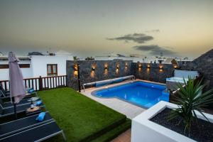 a backyard with a swimming pool and a patio with a yard at Villa Casa Blanca in Playa Blanca