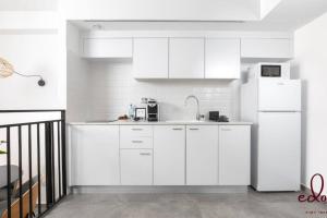 a kitchen with white cabinets and a white refrigerator at דירה משפחתית במיקום מנצח - By Edomlux in Eilat