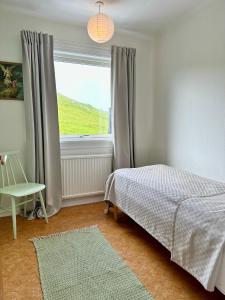 een slaapkamer met een bed en een raam bij Beautiful house in Skopun with jacuzzi in Skopun