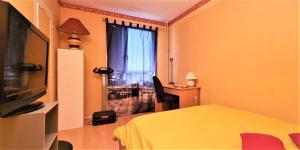 een slaapkamer met een bed, een televisie en een raam bij Superbe chambre à clés Paris in Sartrouville