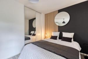 - une chambre avec un grand lit et un miroir dans l'établissement LE GARDEN -MAISON-2Parking-Jardin-Terrasse-Babyfoot-wifi, à Cergy