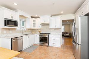 a kitchen with white cabinets and stainless steel appliances at Home near Downtown Vancouver East@ Joyce Skytrain in Vancouver