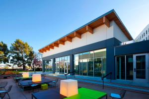 a building with tables and chairs in front of it at Aloft San Francisco Airport in Millbrae