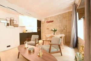 Cosy flat - Saint germain في باريس: غرفة معيشة مع طاولة وكراسي ومطبخ