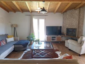 a living room with a couch and a tv at Casa da Ribeira in Alcanede