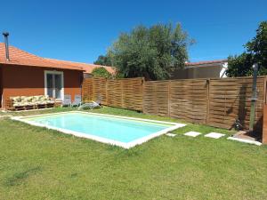 a swimming pool in a yard next to a fence at Casa da Ribeira in Alcanede