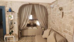 1 dormitorio con 1 cama con cortinas y mesa en Casa Mirabilis 44, en Ostuni
