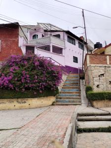 un edificio con flores púrpuras y escaleras delante en Casa Lila, en Mineral del Monte