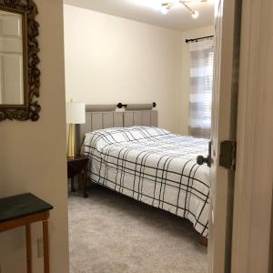 een slaapkamer met een bed, een spiegel en een raam bij Mansfield St in Fredericksburg