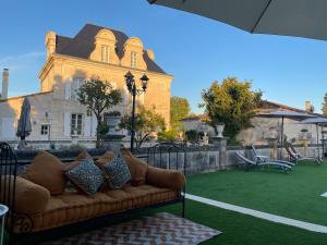 a couch sitting on a lawn in front of a building at Le Grand Berger Chambres D'Hotes 