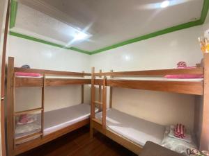 a room with three bunk beds in a room at 3kid's Homestay white in General Luna