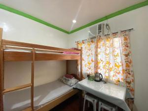 a bedroom with two bunk beds and a window at 3kid's Homestay white in General Luna