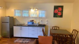 eine Küche mit einer Theke, einem Tisch und einer Mikrowelle in der Unterkunft Tia Maria Retreat in Rarotonga