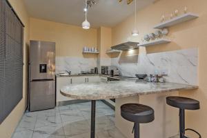 a kitchen with a marble counter and two stools at Azie’s in Roodepoort