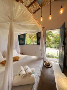 a bedroom with a canopy bed with two towels at Pousada Céu de Corumbau in Corumbau +71 photos