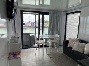 een woonkamer met een tafel en een bank bij Houseboat Cádiz El Puerto - Casa Flotante in El Puerto de Santa María