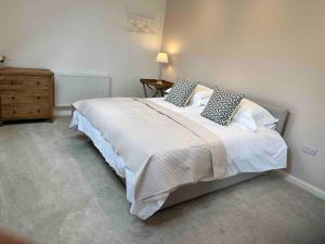 a bedroom with a large white bed with pillows at The Caradoc in Shrewsbury