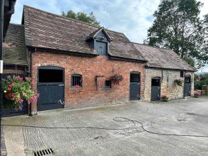 an old brick building with two garage doors and flowers at The Caradoc in Shrewsbury