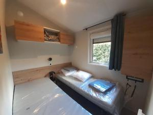 2 Betten in einem kleinen Zimmer mit Fenster in der Unterkunft Chez Laura et Cyril in Gujan-Mestras
