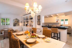 Villa in a palm tree plantation في مربلة: غرفة طعام ومطبخ مع طاولة وكراسي