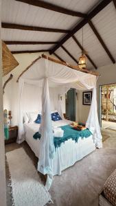 um quarto com uma cama de dossel branca em Pousada Céu de Corumbau em Corumbau