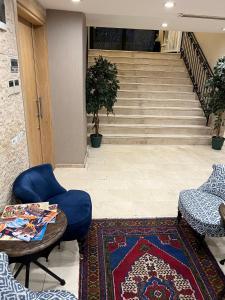 a lobby with a blue chair and a table and stairs at Aybar Hotel & Spa in Istanbul