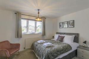 a bedroom with a bed and a chair and a window at Ketley Vallens in Telford