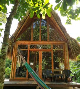 ein Baumhaus mit einer Hängematte davor in der Unterkunft Tiny Houses Unique Tayrona - Dentro del Parque Tayrona in El Zaino