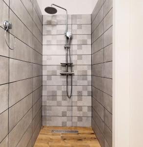 a shower in a bathroom with gray tiles at sobe 1-2-3 in Split