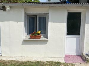 una casa bianca con una finestra e un vaso di fiori sul davanzale di Loue studio meublée les Abrets en Dauphiné 38 a Les Abrets