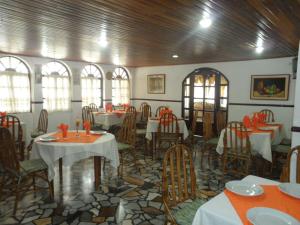 jadalnia ze stołami, krzesłami i oknami w obiekcie Santa Barbara Arauca w Arauca