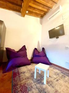 - un salon avec des oreillers violets et une table dans l'établissement Modì Loft, à Livourne