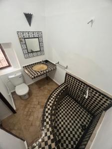 a bathroom with a black and white checkered floor at Riad Ago in Marrakech